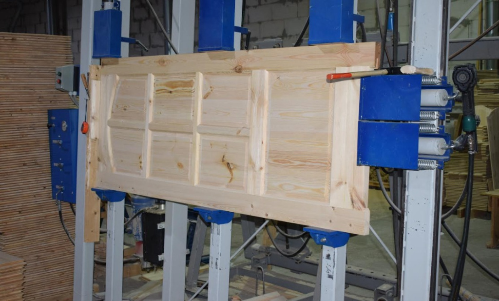 Процесс сборки дверного полотна в прессе