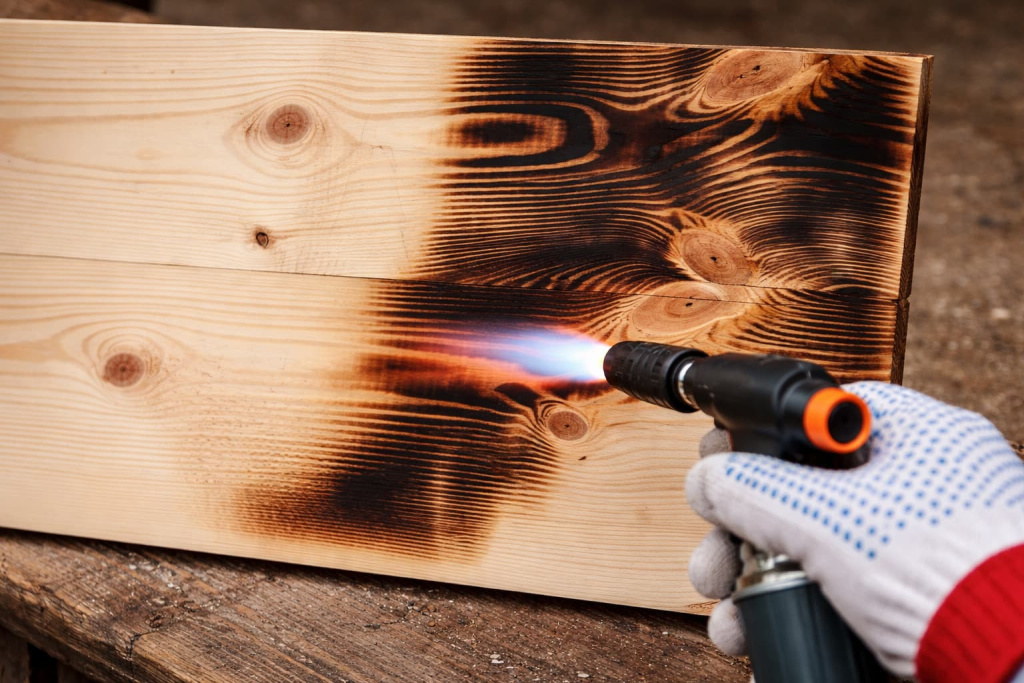 Фото, на котором показан обжиг досок газовой горелкой